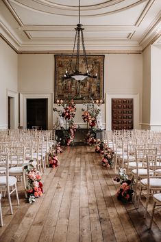 the ceremony room is set up with white chairs and floral arrangements