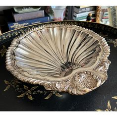 an ornate silver plate on a black table