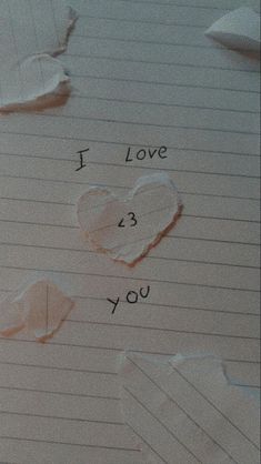 i love you written on lined paper with torn up pieces of paper next to it