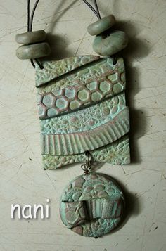 a green necklace with two stone pendants hanging from it's sides