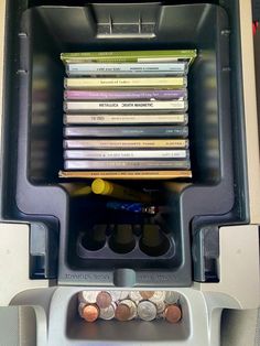 a cash machine with several different types of coins in it's slot and its contents stacked on top