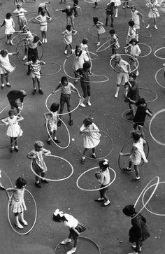 an aerial view of children playing with hula hoop's in a playground area