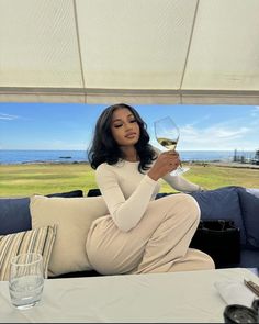 a woman sitting on a couch holding a glass of wine