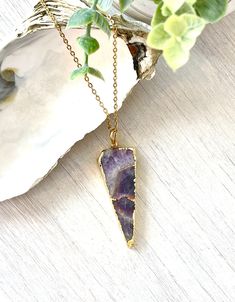 Handmade with positive intentions. Stunning slice of genuine Amethyst made into a gorgeous triangle pendant necklace with 24k gold plating. Pendant is attached to a gold stainless steel diamond cut chain. Amethyst is known for its spiritual protection and purification. Makes a perfect meaningful gift for a birthday, girlfriend or a Valentine's Day gift. Necklace is attached to a Jewelry card displaying the benefits of the stone. Size, shape and color of stone may vary due to the uniqueness of th Amethyst Natural Stones Necklace Gift, Purple Raw Stone Necklaces For Healing, Spiritual Purple Necklace With Large Stone, Amethyst Necklace With Natural Stones As Gift, Purple Raw Stone Necklace For Gift, Purple Necklace With Large Stone For Gift, Adjustable Crystal Necklace With Large Stone As Gift, Purple Crystal Necklaces With Natural Stones As Gift, Spiritual Arrowhead Necklace Gift