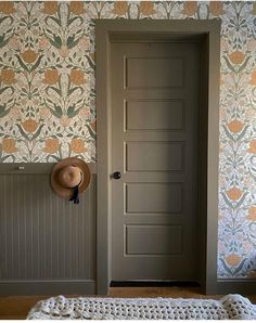 a room with a bed and a hat on the headboard next to a door