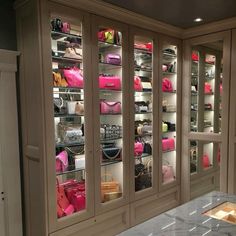 a room filled with lots of purses and handbags on shelves next to a counter