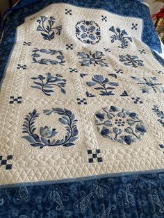 a blue and white quilt on top of a bed