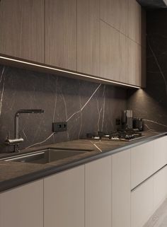 a modern kitchen with marble counter tops and white cabinetry, along with stainless steel sink faucets