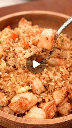 a wooden bowl filled with shrimp and rice