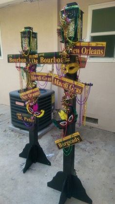 two street signs with mardi gras decorations on them