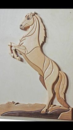 a wooden cutout of a horse standing on it's hind legs and tail