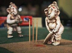 two small statues of elephants playing cricket