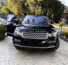 a black range rover parked in front of a house next to another car with the name range rover on it