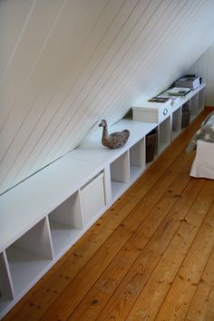 a bed room with a neatly made bed and some shelves on the wall next to it