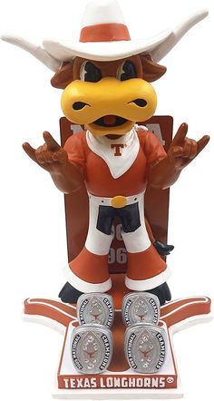 the texas longhorns mascot is posed on top of an award plaque with his hands in the air