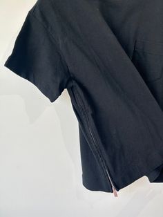 Sacai Black Cotton Tee with Neck Buckle and Side Zippers. A fun take on a classic t-shirt, with breast pocket, silver buckle at the collar and silver zippers going up either side of the torso. 100% cotton, hand wash. Made in Japan. Excellent used condition. Marked size 2, fits like a boxy Medium. Approx. Measurements: Underarm to underarm: 21' Length: 24" Black Collared Top With Side Pockets, Silver Zipper, Black Cotton, Made In Japan, Side Zipper, Cotton Tee, Classic T Shirts, Size 2, Hand Wash