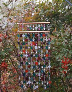 a multicolored beaded mobile hanging from a tree