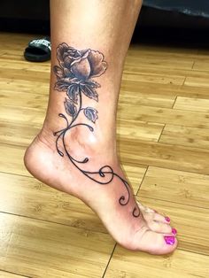 a woman's foot with a rose tattoo on the top and bottom of it