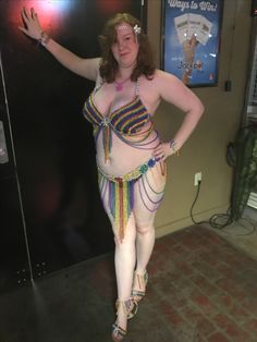 a woman in a belly dance costume standing next to a wall with an advertisement on it