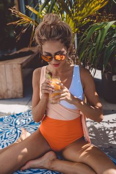 The one set to make a statement. This swimsuit’s tri-colour block in orange takes its inspiration from the ocean’s colourful fish and coral. The one-piece bathing suit has a medium plunging front and back, tied with a cute bowknot at the waist, which flatters and accentuates the waistline. Picture this: Spreading out in the sand and soaking up some rays after a refreshing morning swim. Worn by the lovely @rahelchiwitt ﻿(wearing S). Morning Swim, Colourful Fish, International Clothing, Colorful Fish, One Set, Tri Color, Beach Day, Bathing Suit, The Ocean