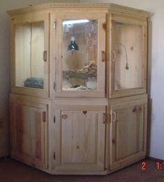 a wooden china cabinet with glass doors in a living room or dining room area next to a wall