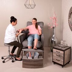 two women are sitting in chairs and one is getting her hair done by another woman