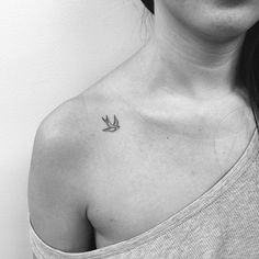 a woman with a small bird tattoo on her chest