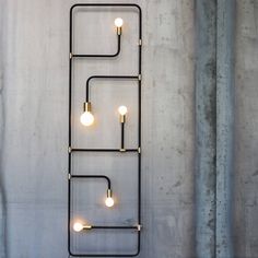 a metal shelf with lights on it against a concrete wall in an industrial style setting