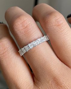 a woman's hand with a wedding band on it and the ring is in white gold