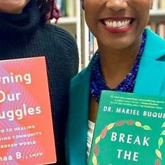 two women standing next to each other with books in front of their faces and smiling at the camera