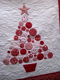 a quilted christmas tree with red and white buttons on it's center piece