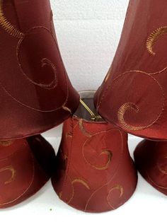 four red lamps with gold swirl designs on them