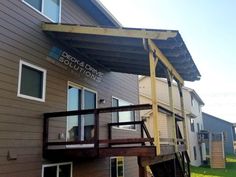 an outside view of a building with some windows and a wooden deck attached to the side of it