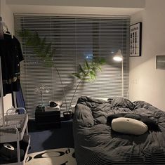 a bed room with a neatly made bed and a plant