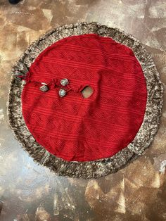 a red and grey round rug with buttons on it