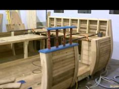 a wooden boat is being built in a room with other woodworking tools on the floor