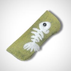 "Green felt eyeglasses case. Hand stitched, fun felt folk art fish skeleton (say that 5 times fast!) with beaded eye on front side. Blanket stitch closes side and bottom. Lining is complimentary colorful fabric (not shown and varies between cases). Not suitable for oversized glasses but perfect for regular sized glasses, sunglasses and readers. Dimensions are 6.75\" x 2.75\" but may vary ever so slightly due item being handmade. Glasses in photo are for demonstration purposes only and do not com Glasses Case Painting, Cross Stitch Glasses Case, Wet Felted Glasses Case, Embroidered Sunglasses Case, Glasses Case Leather Handmade, Fish Skeleton, Folk Art Fish, Blanket Stitch, Eyeglass Case