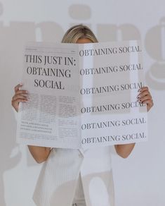 a woman is holding up two newspapers with words on them that read, this just in obtain social