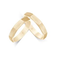 two gold wedding bands with hearts on them