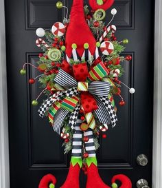 a christmas door hanger decorated with red and green stockings, candy canes and ornaments