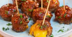 some meatballs with toothpicks on a plate