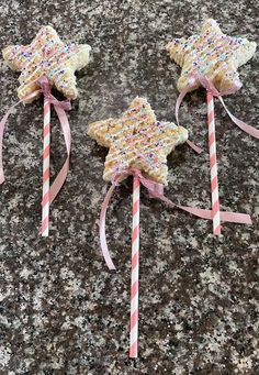 three star shaped lollipops with sprinkles on them sitting on a counter