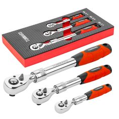 three wrenches and two pliers in front of a box with tools inside it