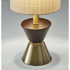 a table lamp with a wooden base and a beige shade on the top of it