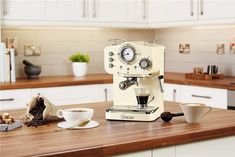 a green coffee machine sitting on top of a wooden counter