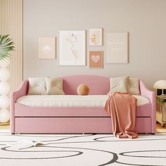 a living room with pink furniture and pictures on the wall