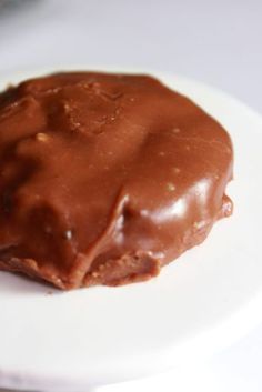 a piece of chocolate covered doughnut on a white plate