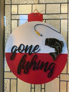 a fishing ornament hanging on the side of a glass door that says gone fishing