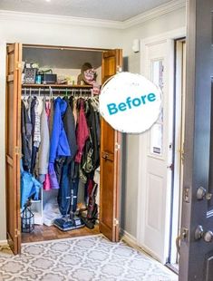 an open closet with clothes hanging on the door and a rug in front of it