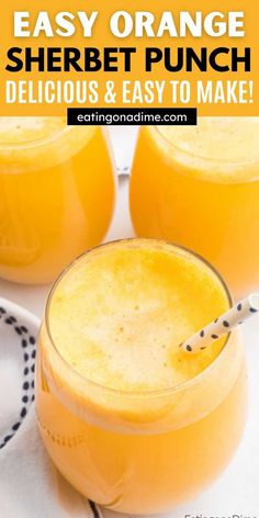 two glasses filled with orange sherbet punch sitting on top of a white table